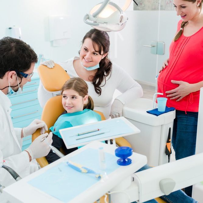 Dentist in office with child and parents