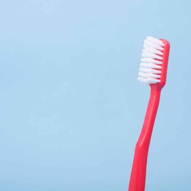 Red toothbrush on blue background