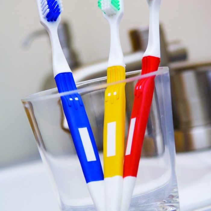 Three toothbrushes in glass